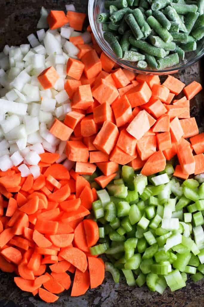Chopped vegetables on a black cutting board.