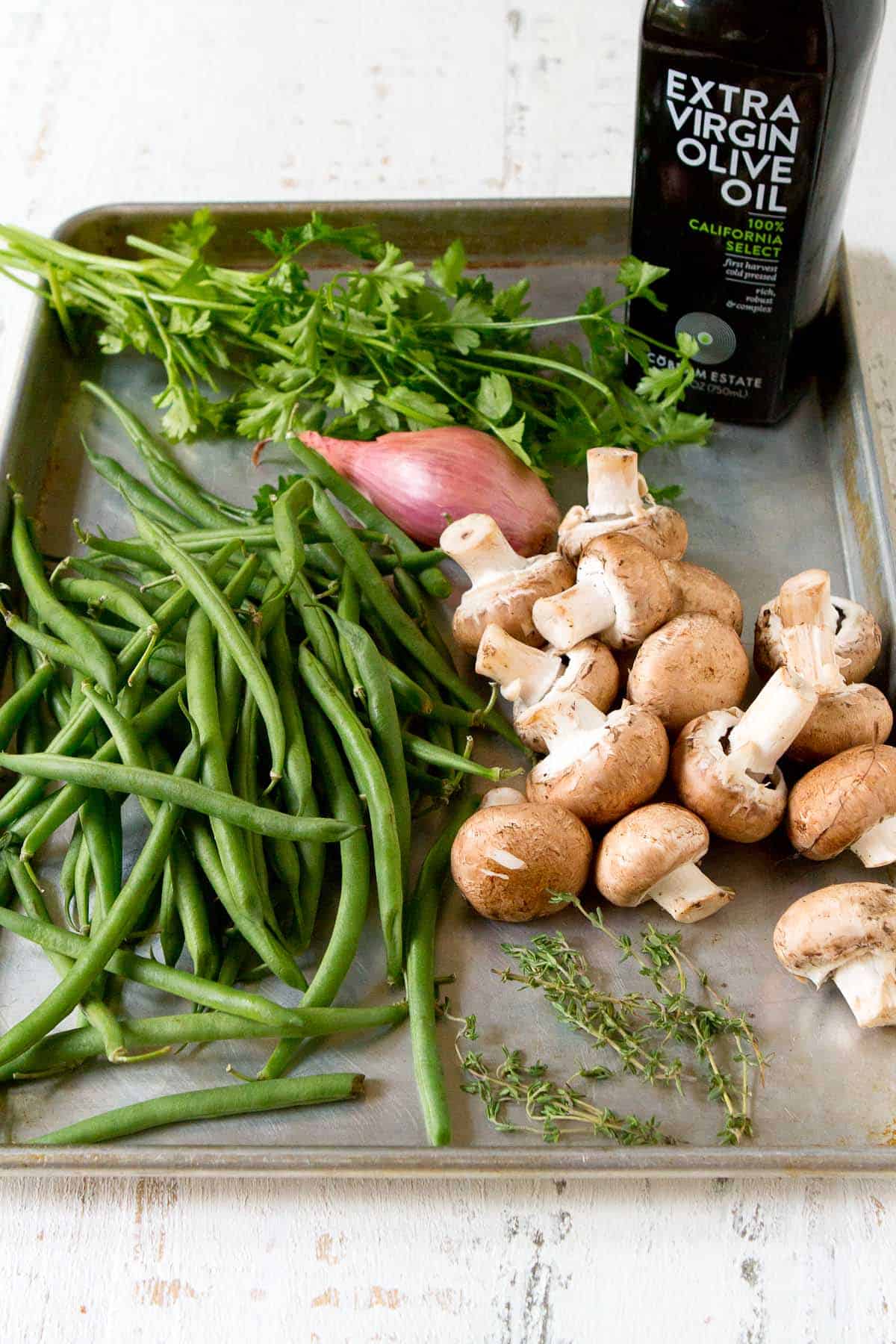 Ingredients for green beans and mushroom side dish on a baking sheet.