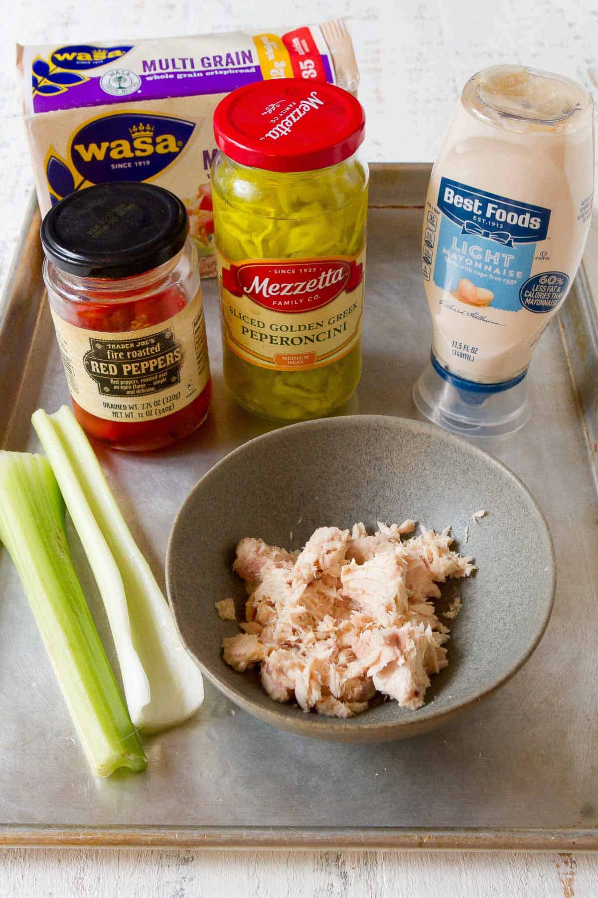 Tál tonhal, majonézes üvegek, sült paprika és pepperoncini, mindezt tepsiben.