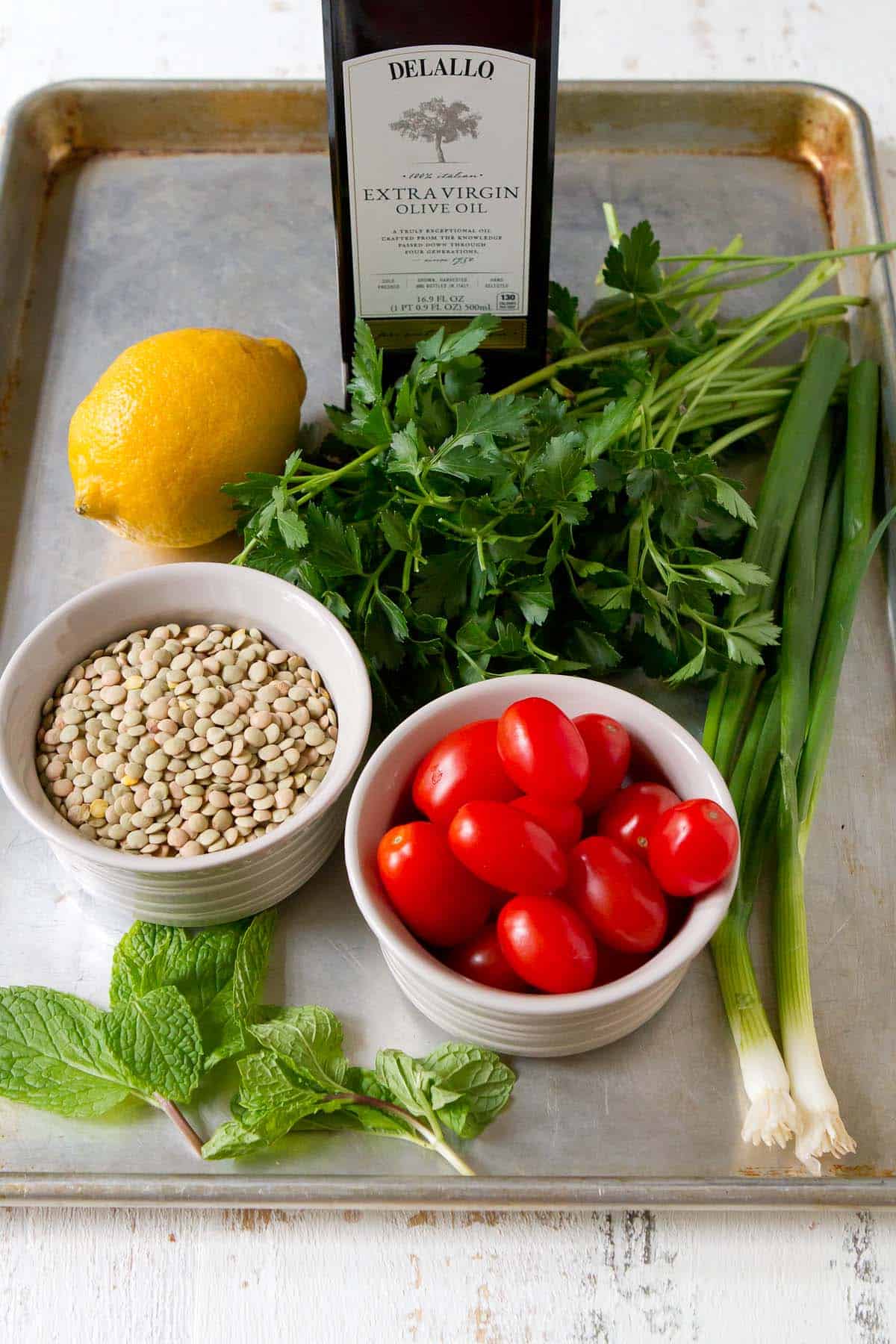 Ingredients for lentil tabbouleh salad on a baking sheet.