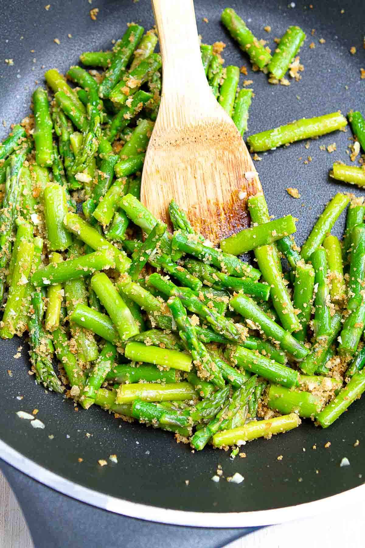 Pieces of sauteed asparagus with garlic breadcrumbs in a large nonstick skillet.