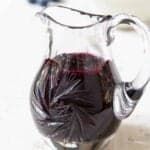 Blueberry syrup in a small crystal pitcher.