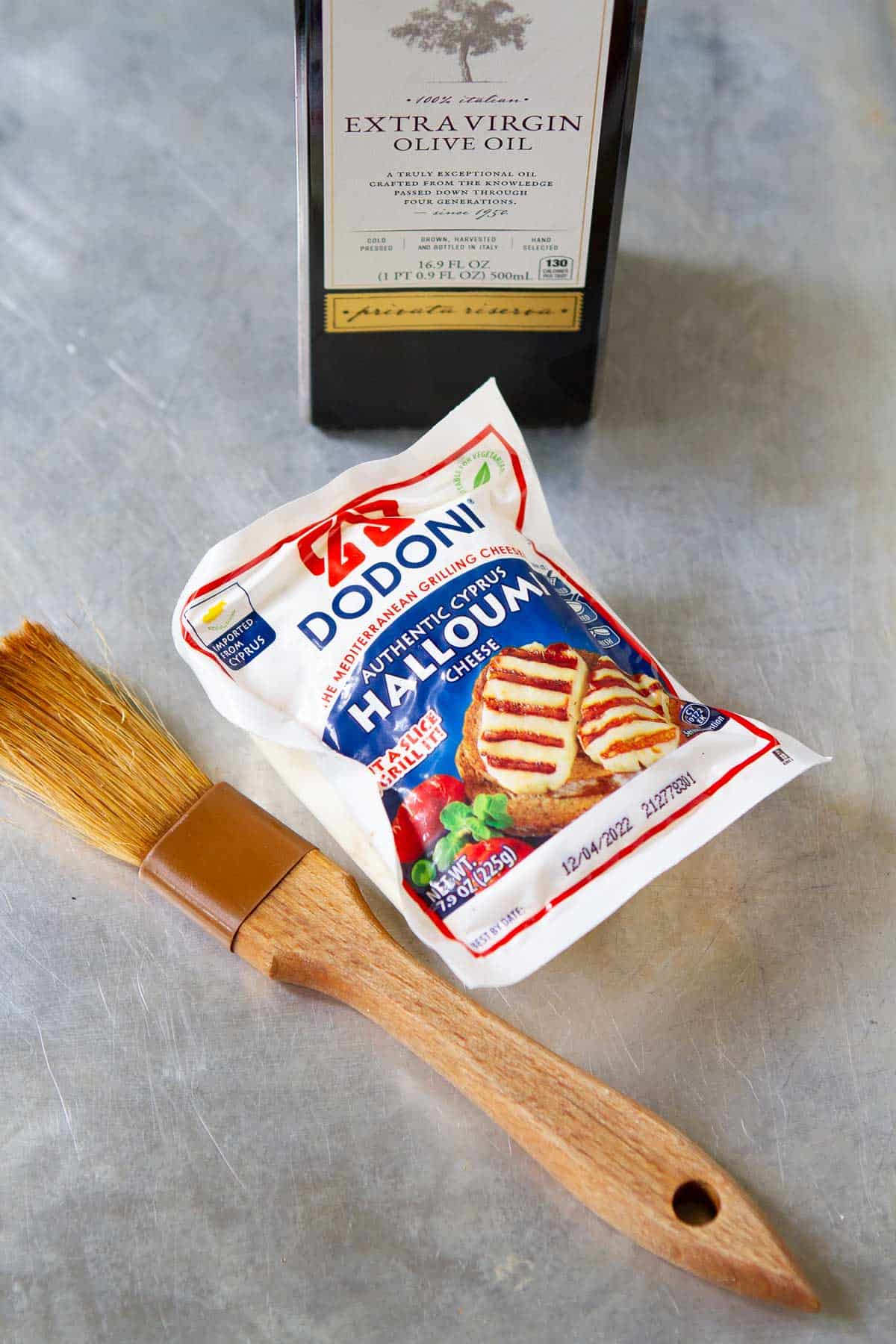 A block of halloumi, olive oil and pastry brush.