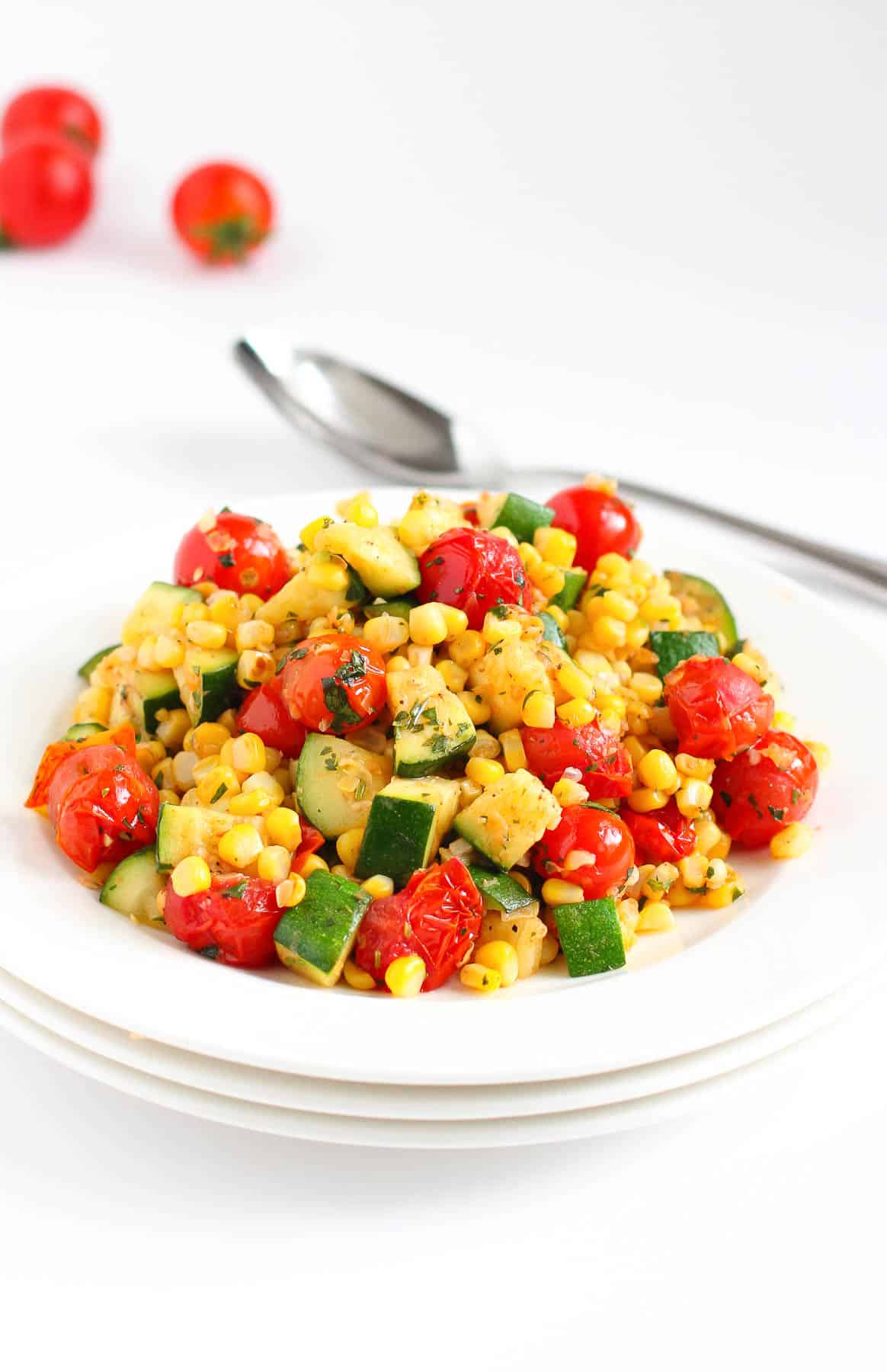 This easy side dish is bursting with summertime flavors! Sautéed corn and zucchini mix with blistered tomatoes, lime juice, garlic and herbs. Simple and delicious! | Recipes | Side dishes | Vegan | Plant based