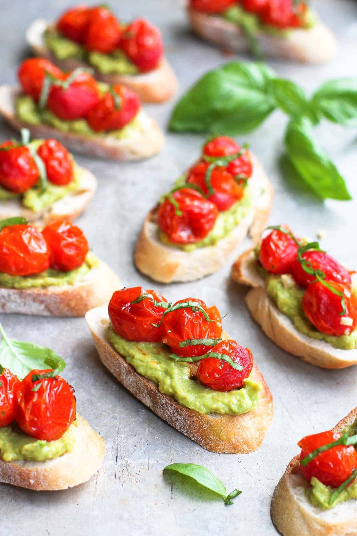 Roasted tomato crostini are fantastic on their own, but even better with added smashed avocado and basil. The best summer appetizer! | Appetizers | Vegetarian | Vegan | Plant-Based | Recipes