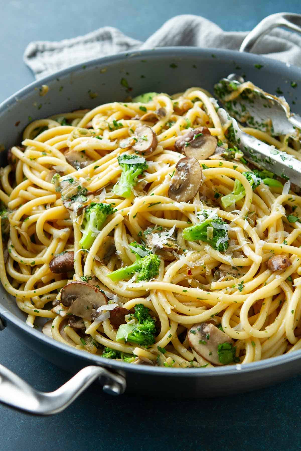 Bucatini pasta with broccoli and mushrooms in a large nonstick skillet.