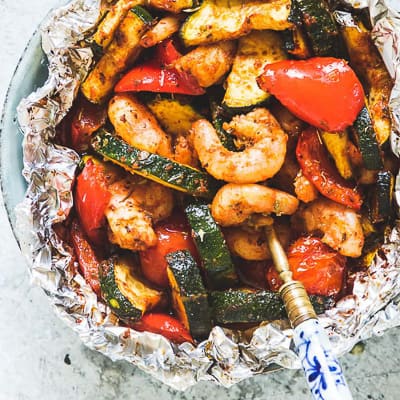 Cooked shrimp and vegetables in a foil packet.