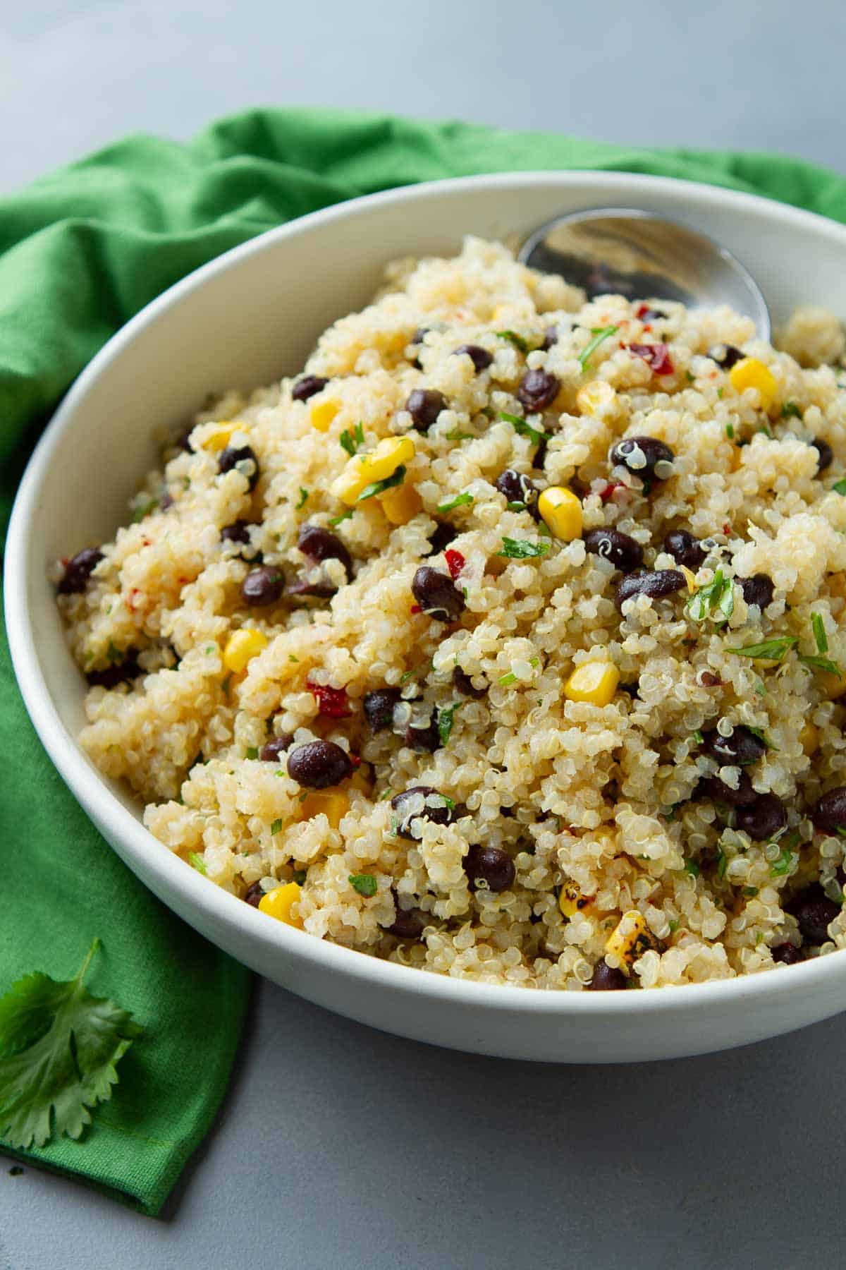 White bowl filled with quinoa, black beans and corn.