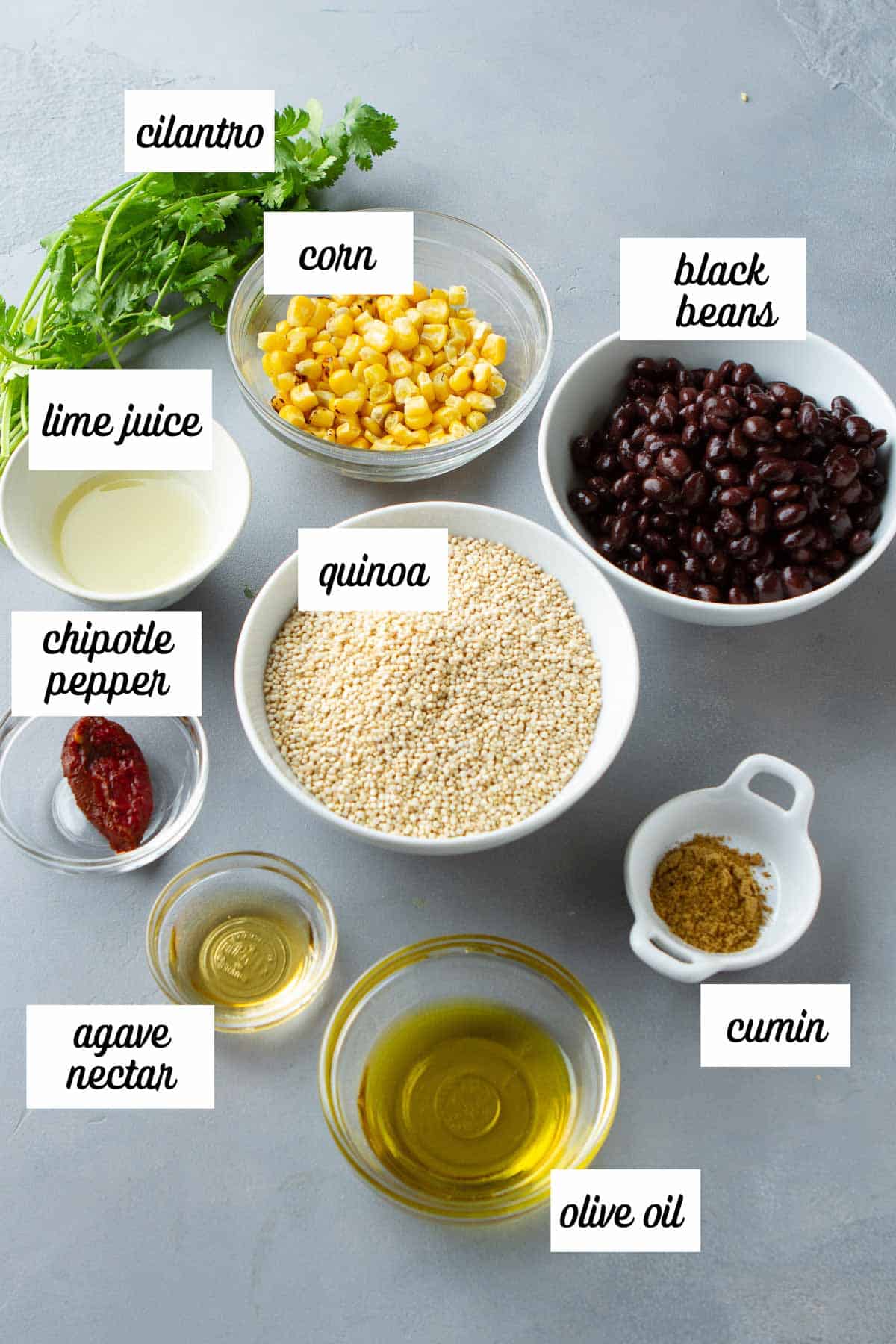 Labeled ingredients for southwest quinoa salad on a gray background.