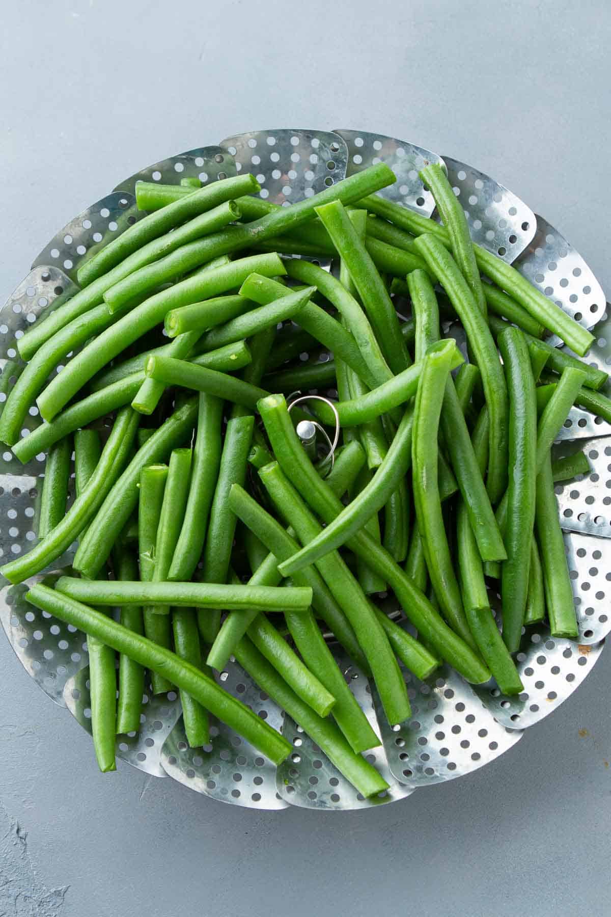 Green beans in a steamer basket.