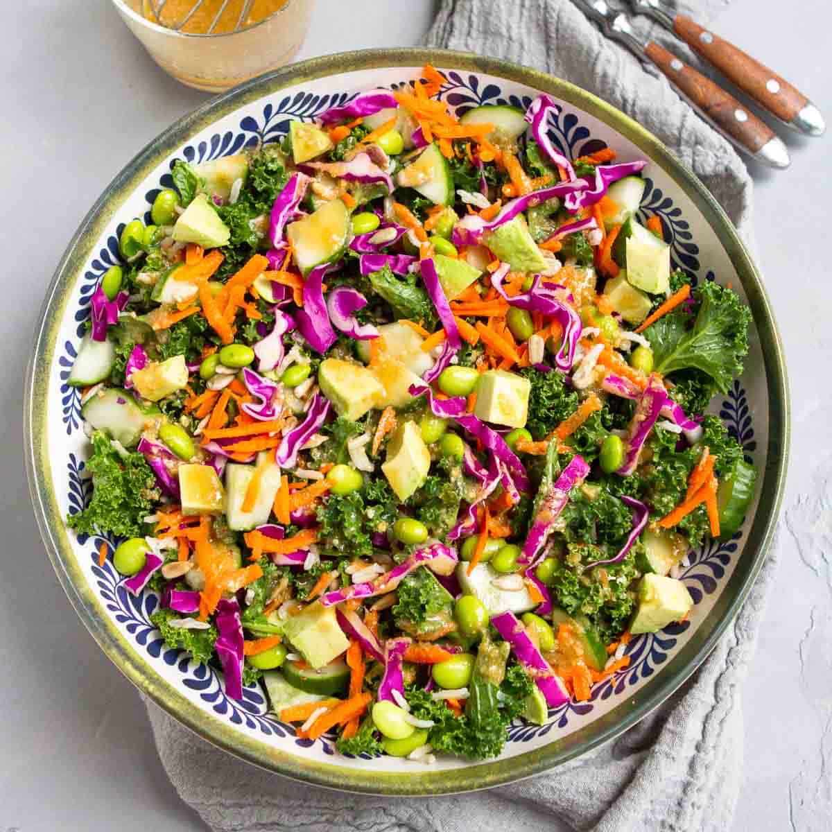 Kale salad with avocado, cabbage rice and other vegetables in a large bowl.