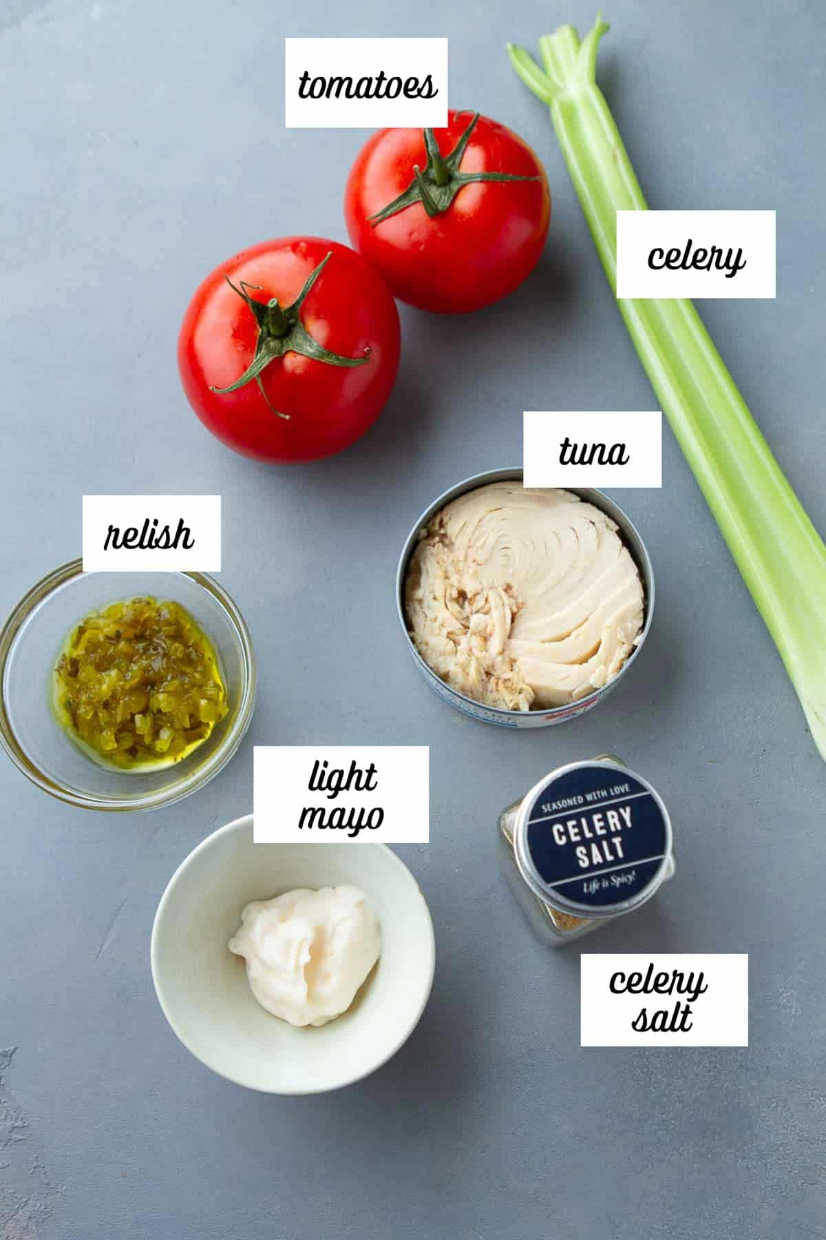 Labeled ingredients for tuna salad stuffed tomatoes.