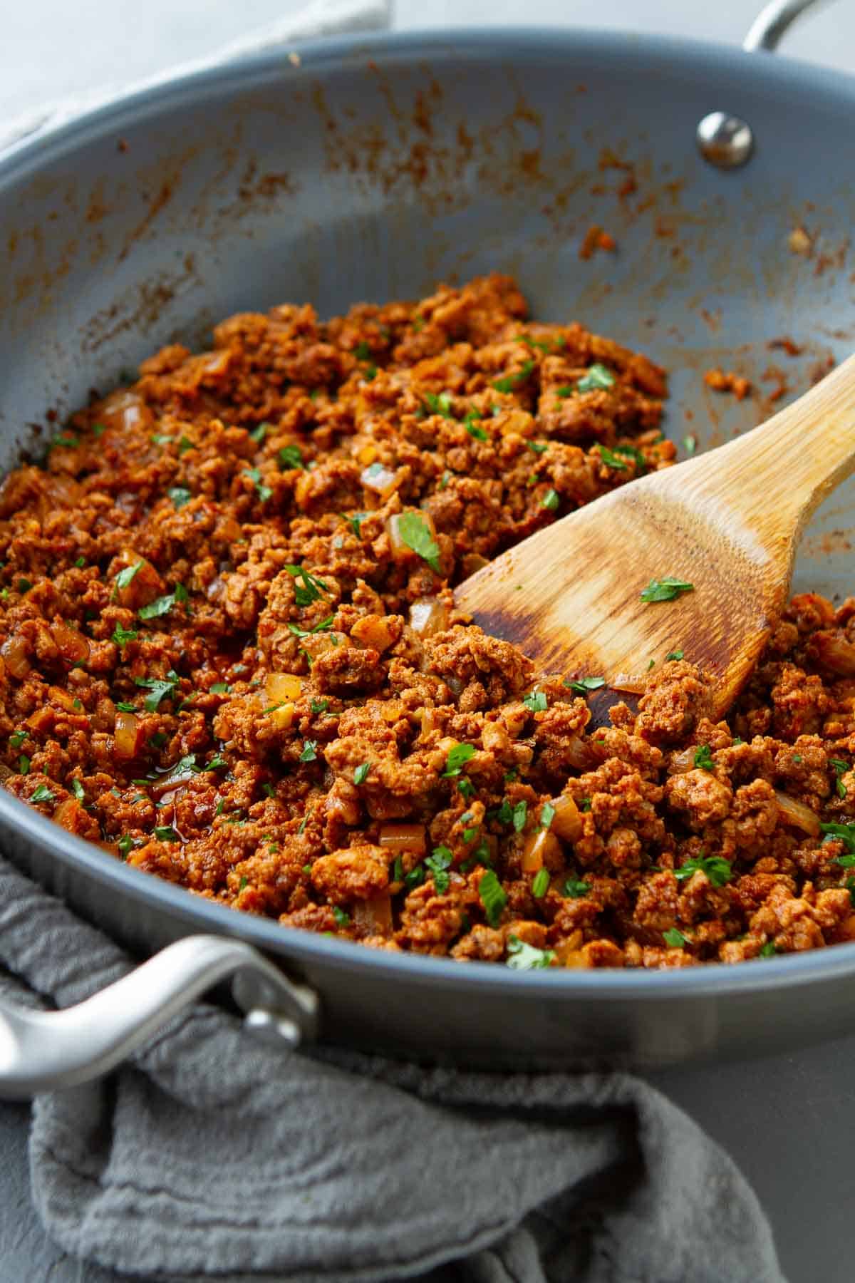 Taco seasoned ground meat in a blue skillet.