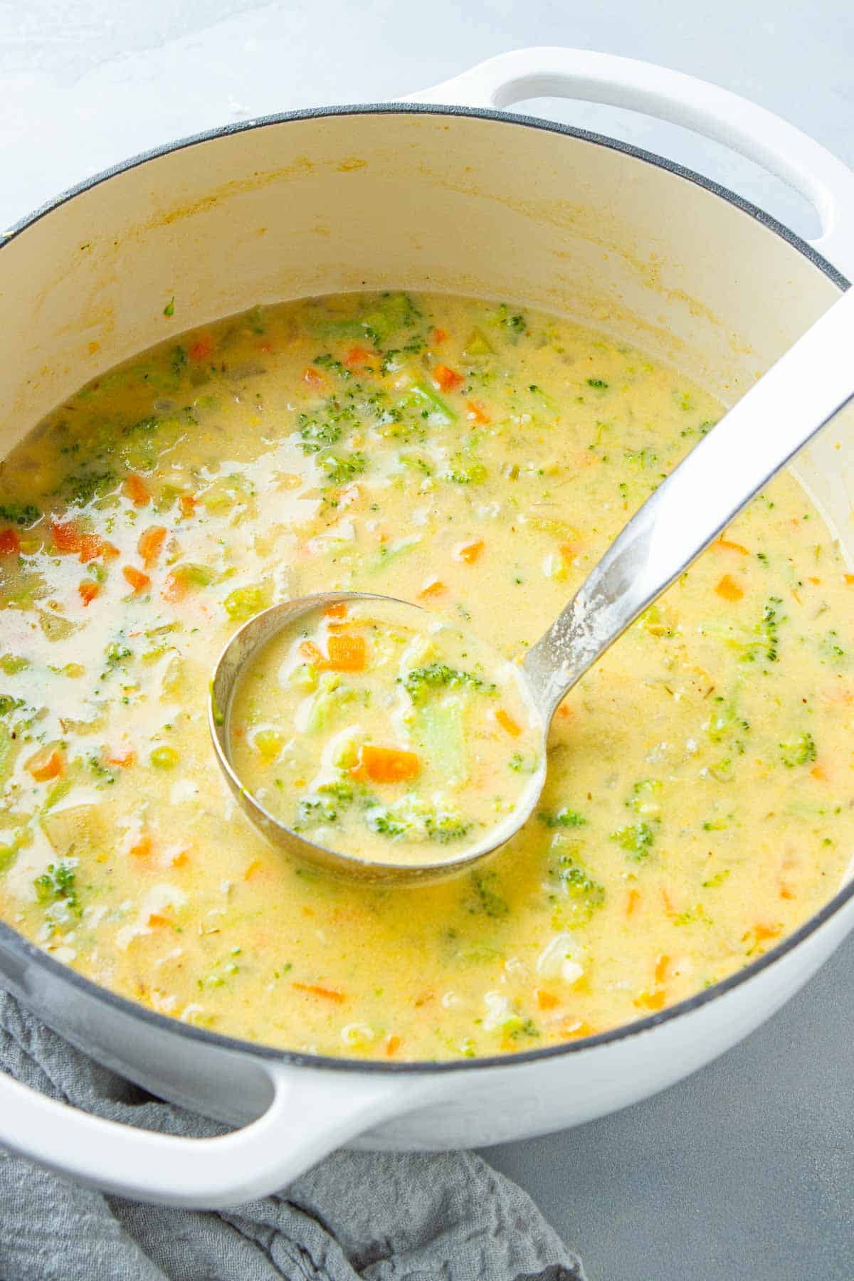 A large pot of creamy soup with broccoli and potato.