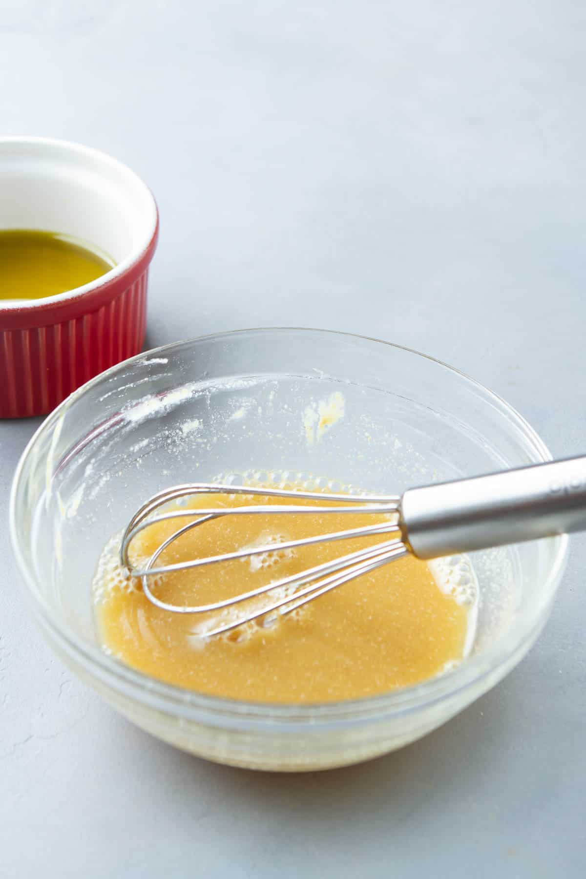 Salad dressing and a whisk in a small glass bowl.