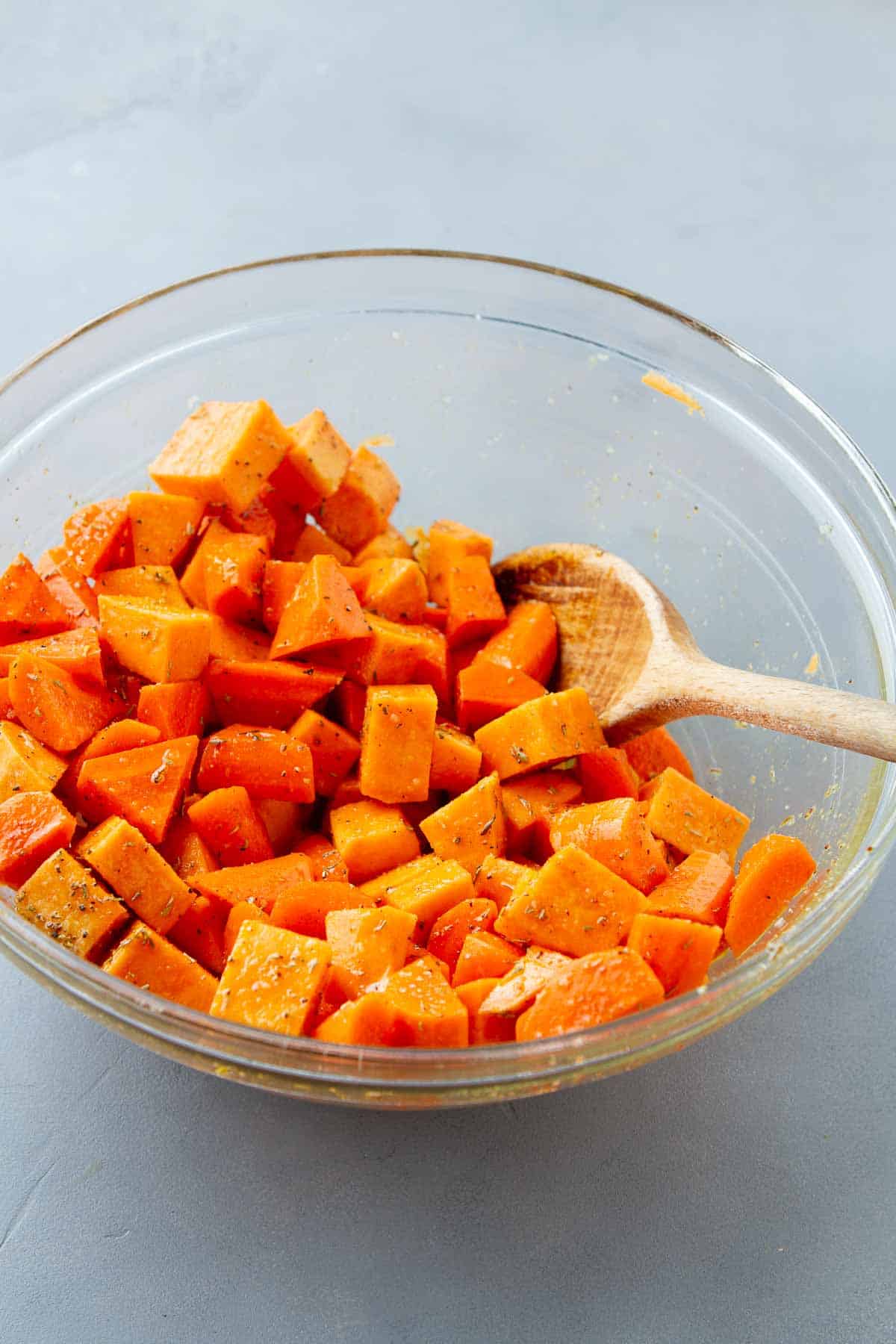 Chopped sweet potatoes and carrots in a glass bowl.