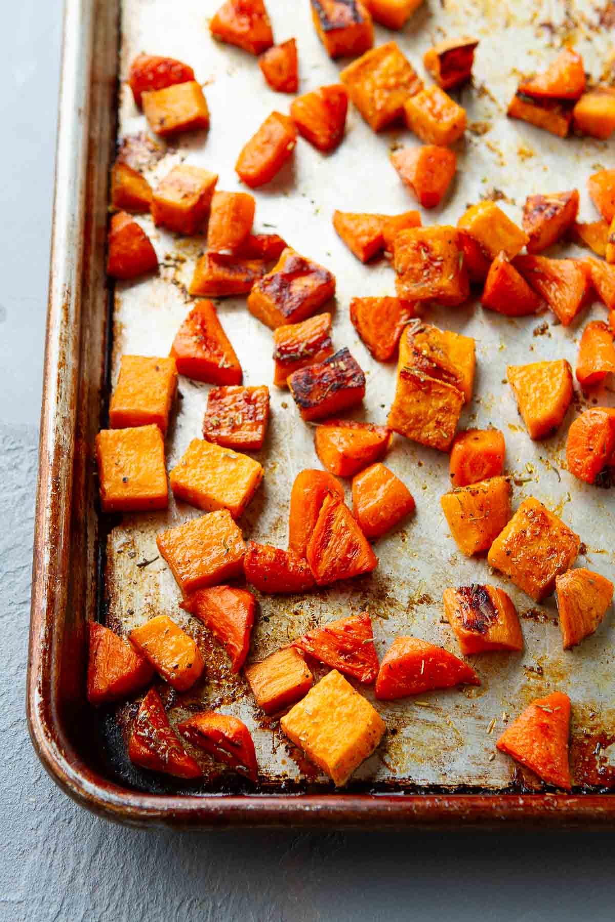Roasted carrots and sweet potatoes on a baking sheet.