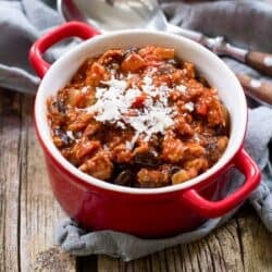 Ground turkey and bean chili in a small red bowl with handles