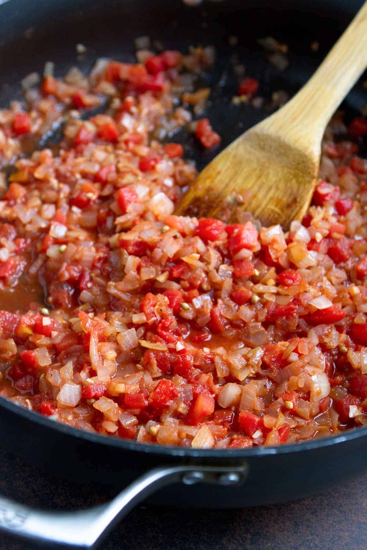 Cooked onions, spiced and diced tomatoes in a large skillet.