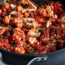 Cauliflower and tomato sauce with olives in a large skillet.