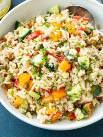 Rice salad with tuna and vegetables in a white bowl.