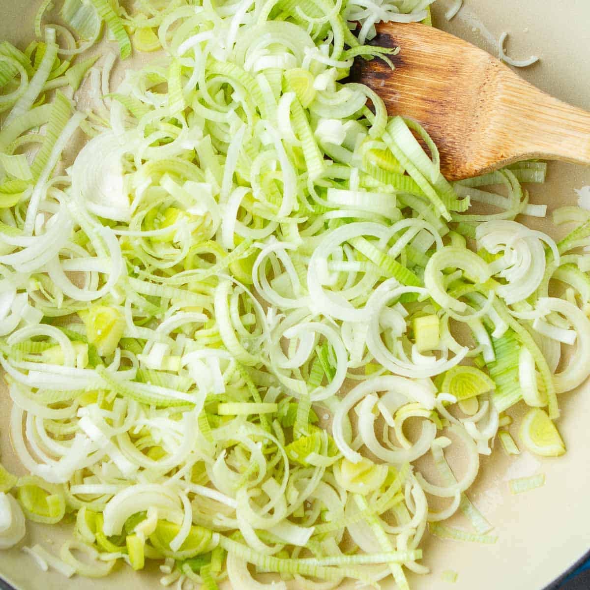 Raw slices of leek in a skillet.