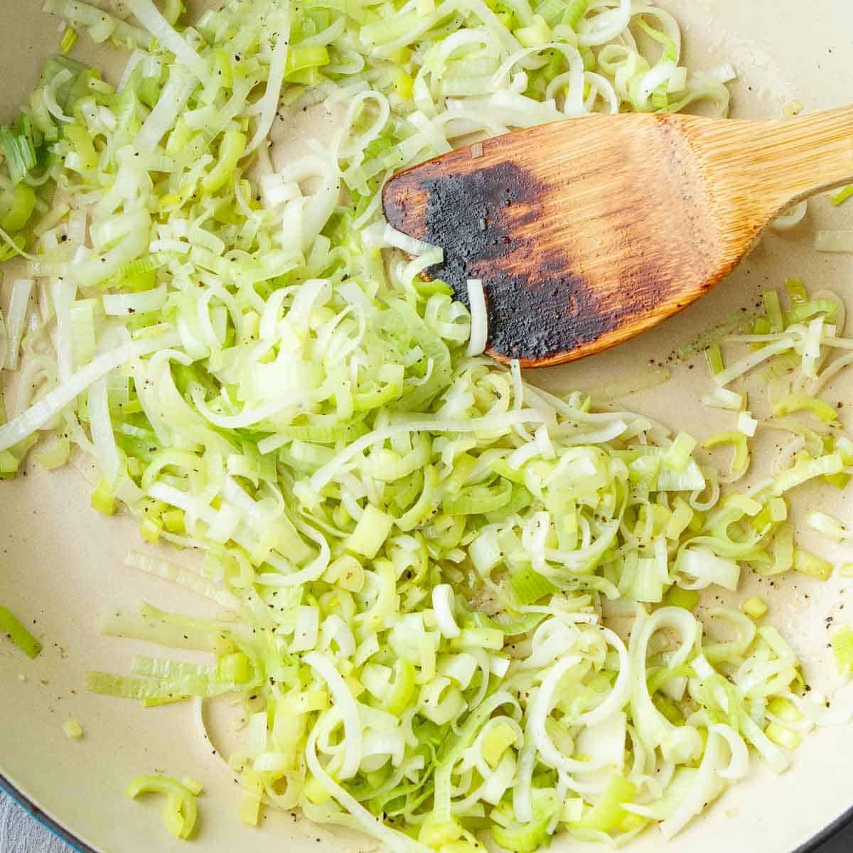 Cooked leek slices in a skillet.