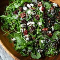 Arugula wild rice salad in a wooden salad bowl.
