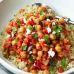 Chickpea stew with tomatoes, olives and quinoa in a bowl.