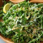Arugula salad with Parmesan and panko in a wooden bowl.