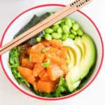 Salmon poke, avocado and edamame in a bowl.