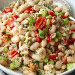 Tuna white bean salad with tomatoes in a white bowl.
