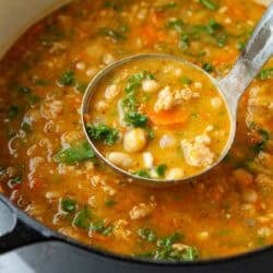 Sausage, bean and kale soup in a saucepan.